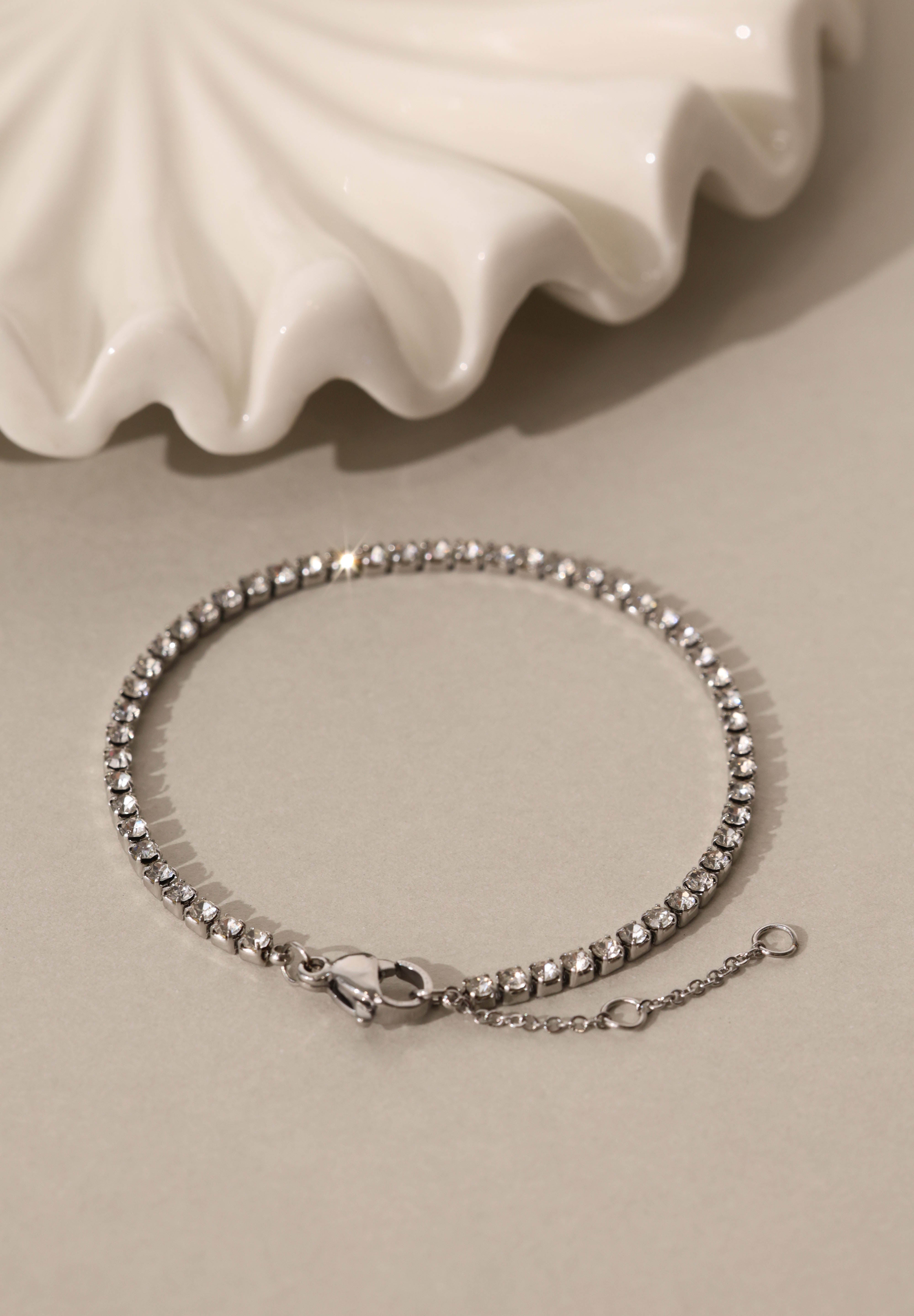 Skinny 2.5mm stainless steel tennis bracelet with sparkling stones, waterproof design, casual yet elegant, paired with matching necklace.