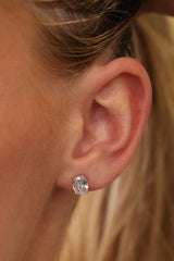 Silver Adamas oval stud worn on an ear — a 1.25 carat oval cubic zirconia in a four-prong setting.