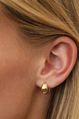Gold Cleo huggie hoop earrings — close view of the smooth dome and 9mm hoop opening.