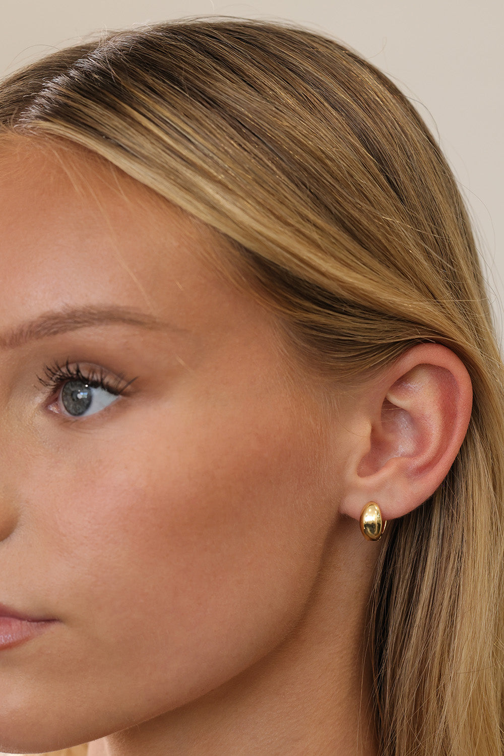 Gold Cleo huggie hoop earrings — the hinged snap closure shown open and closed.