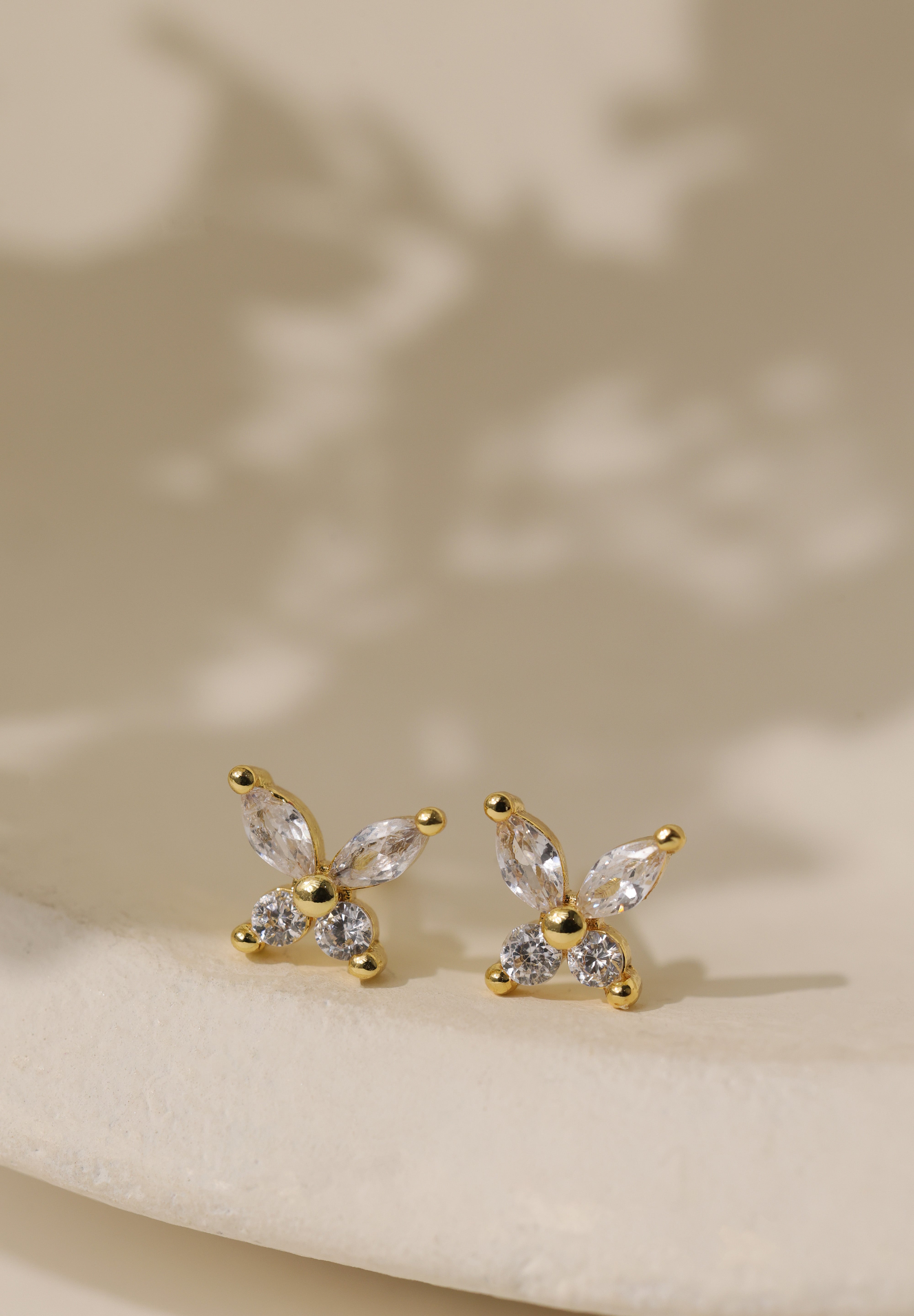 Gold butterfly cubic zirconia stud earrings — two marquise-cut wings above two round brilliant stones.