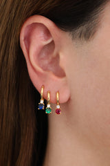 Gold hoop earrings with colorful gemstones in pink, clear, black, purple, green, and black.