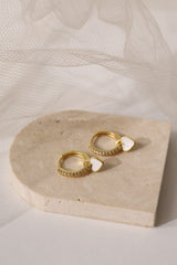 Dainty white gold–plated hoop earrings with pave cubic zirconia and a removable heart charm, shown in four colour variations, available in gold and silver finishes.