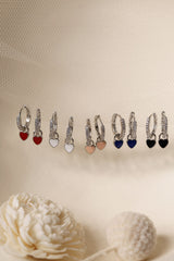 Dainty white gold–plated hoop earrings with pave cubic zirconia and a removable heart charm, shown in four colour variations, available in gold and silver finishes.