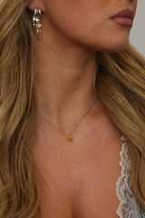 Woman wearing a personalised silver birthstone pendant necklace with pear-cut cubic zirconia stones