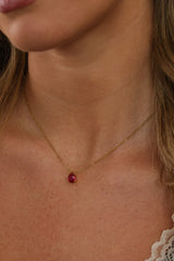 Model wearing a gold birthstone necklace with two pear-cut stones set side by side on a fine cable chain