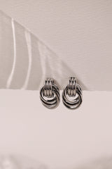 Silver interlocking ring earrings with a polished knot design that reflects light beautifully.