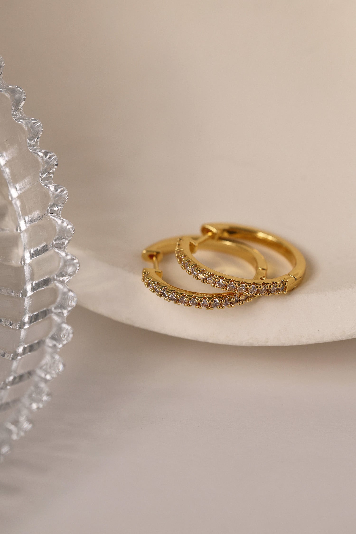 25mm gold hoop earrings with cubic zirconia stones that reflect light, shown as a versatile everyday jewellery piece.”