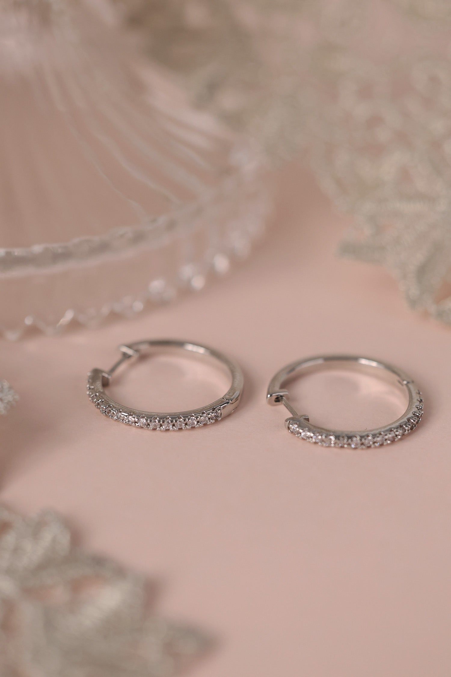 25mm silver hoop earrings with cubic zirconia stones that reflect light, shown as a versatile everyday jewellery piece.