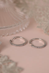 25mm silver hoop earrings with cubic zirconia stones that reflect light, shown as a versatile everyday jewellery piece.