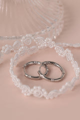These elegant silver hoop earrings are meticulously crafted from brass with white gold plated featuring intricate floral inlaid cubic zirconia detailing in both inside and outside of the hoops.
