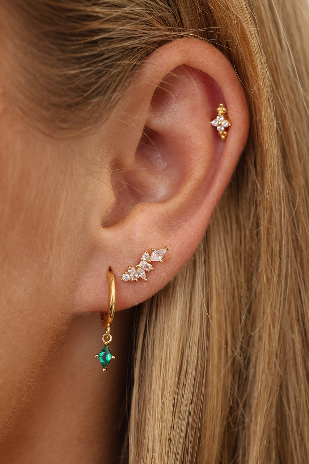 Green gemstone and clear stone sterling silver ear stack on model