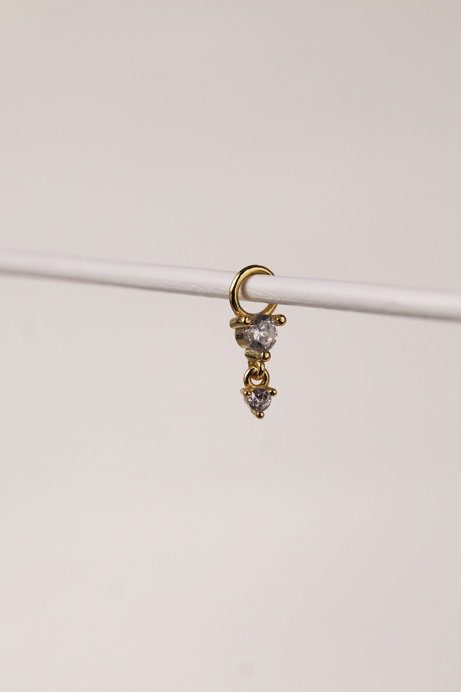 Gold hoop charm featuring two clear faceted gemstones in a tiered drop design.