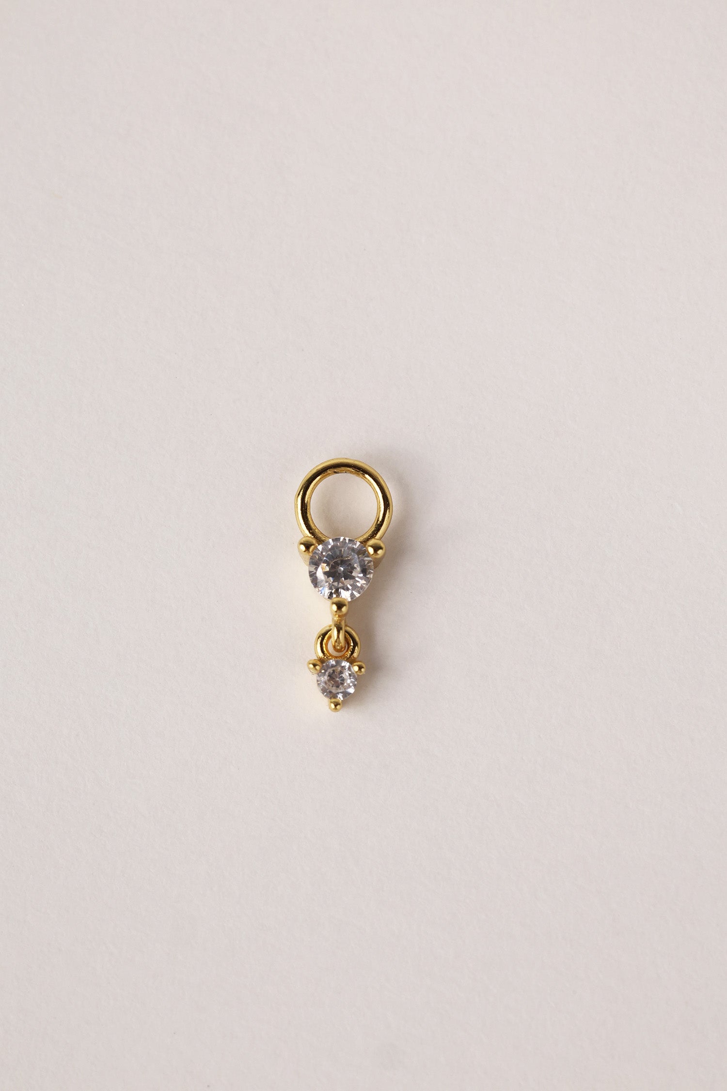 Gold hoop charm featuring two clear faceted gemstones in a tiered drop design.