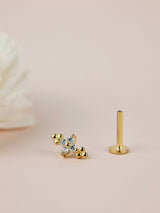 Gold earring with clear gemstones on a beige background FLAT BACK STUD