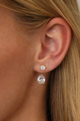 Gold Adamas ear jacket worn — a round cubic zirconia stud on the lobe with the pear-cut drop hanging below it.