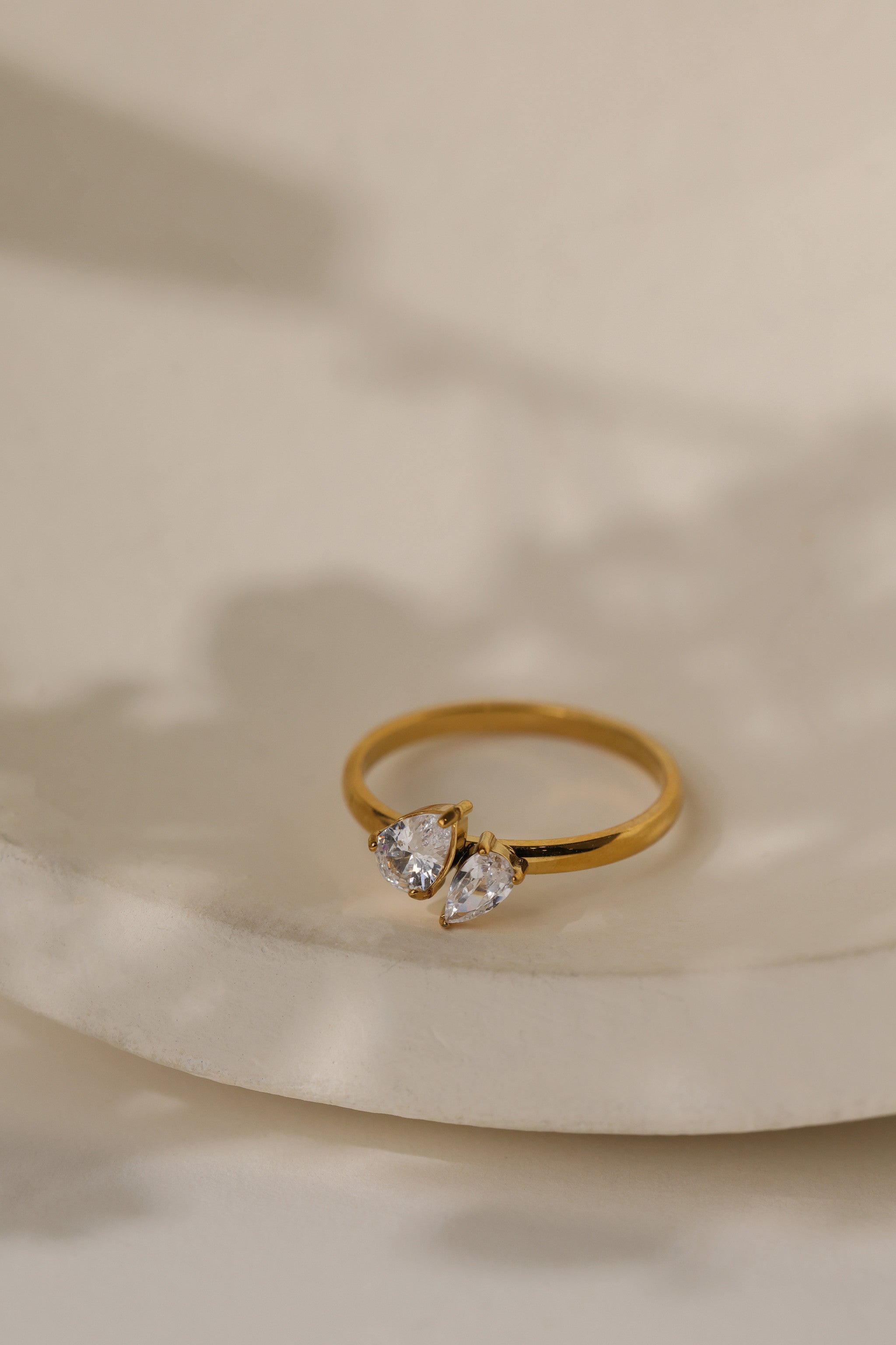 Elodie toi et moi pear ring in gold on a cream ceramic dish