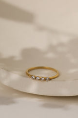 Willa four stone ring in gold on a cream ceramic dish