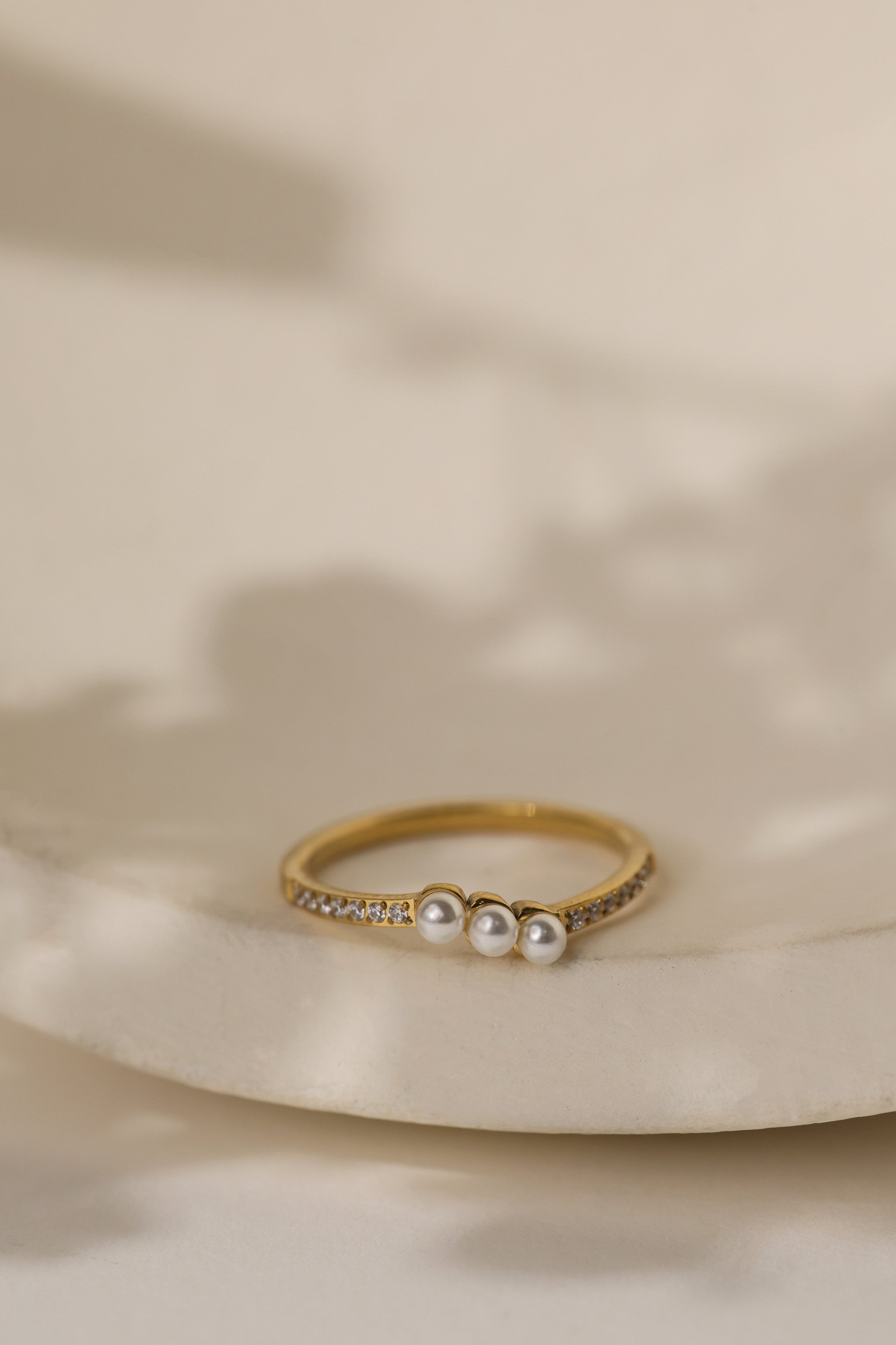 Juliette three pearl ring in gold on a cream ceramic dish
