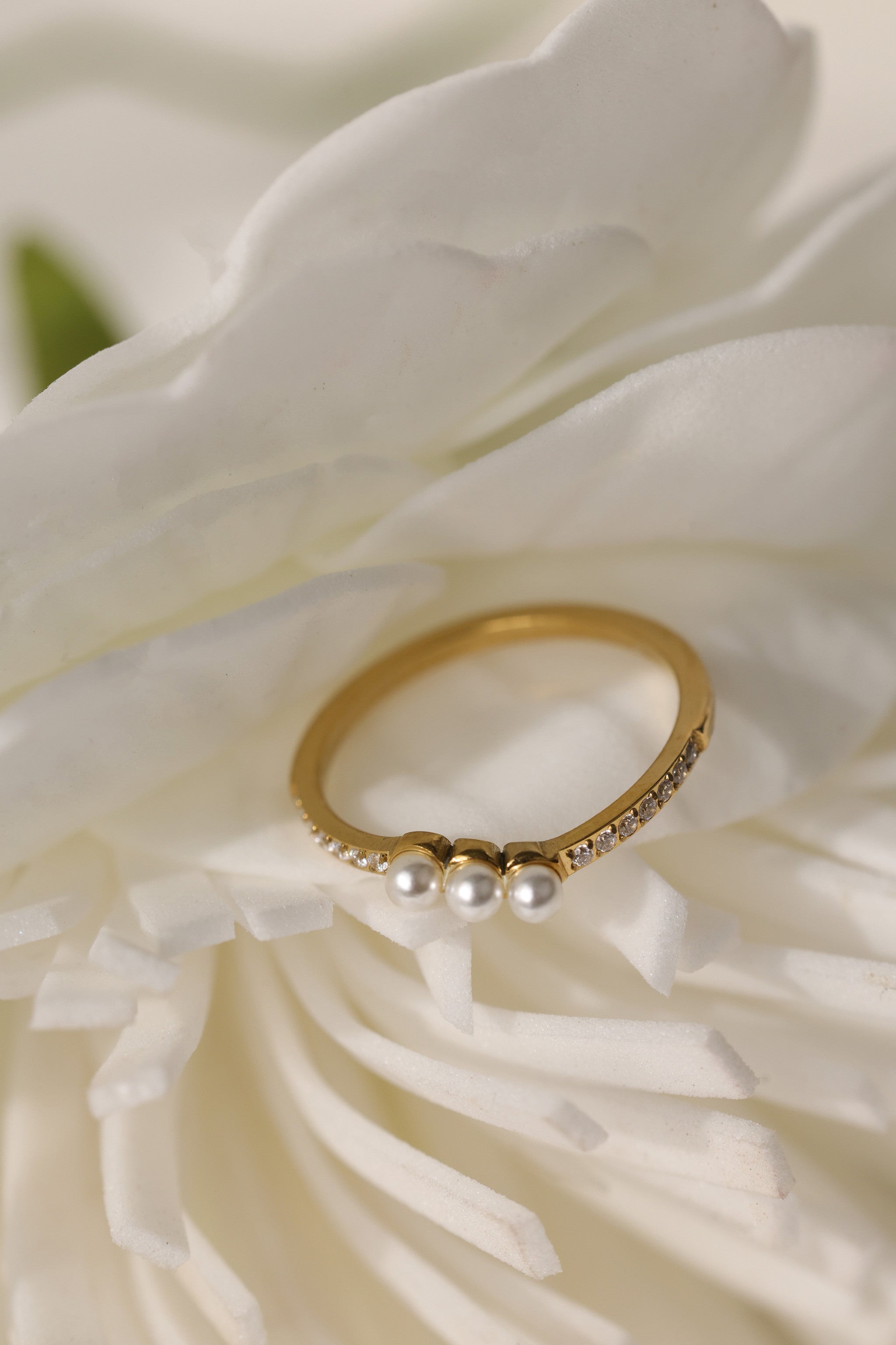 Juliette three pearl ring in gold beside a white flower