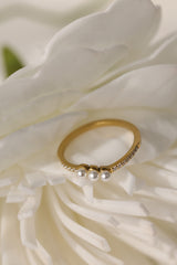 Juliette three pearl ring in gold beside a white flower