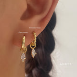 Premium teardrop earrings featuring shiny 18k gold-plated cubic zirconia charms on 925 sterling silver hoops.