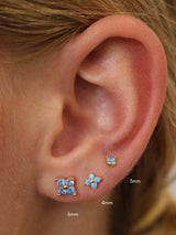 Size guide showing gold 4 clover blue stud earrings in 3mm, 4mm and 6mm on a model's ear