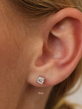 Silver princess-cut cubic zirconia stud earring worn on the lobe, shown at 5mm for scale.