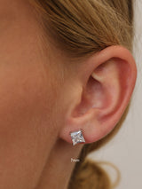 Silver princess-cut cubic zirconia stud earring worn on the lobe, shown at 7mm for scale.