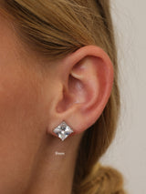 Silver princess-cut cubic zirconia stud earring worn on the lobe, shown at 9mm for scale.