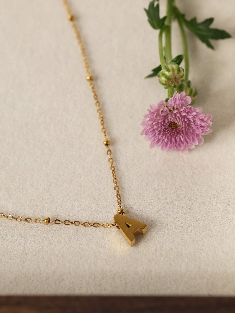 Lilia Initial Gold Necklace — a personalised stainless steel necklace featuring an elegant initial charm and birthstone option. Waterproof, tarnish‑resistant and perfect for gifting. A meaningful everyday piece designed for effortless elegance