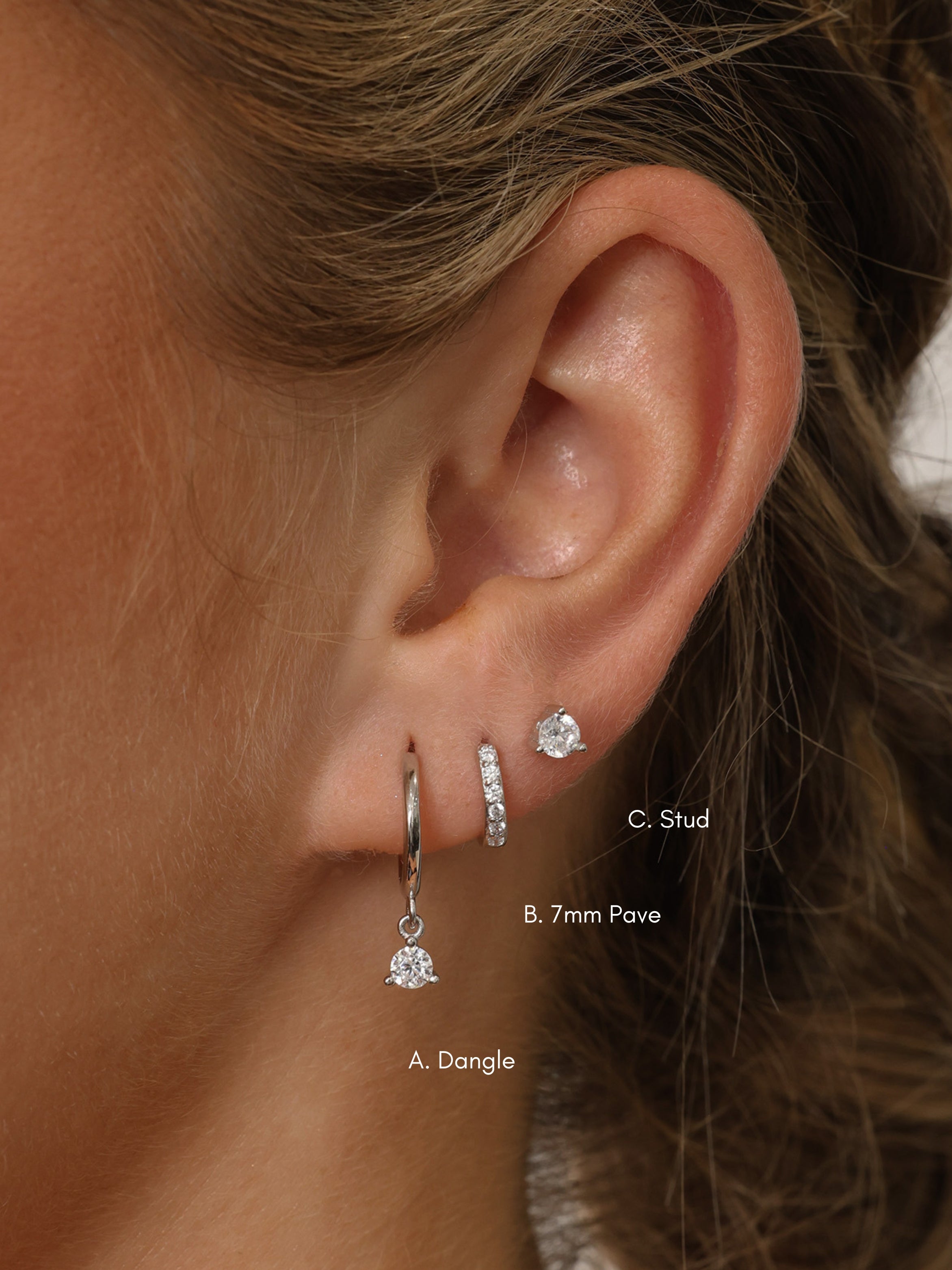 A three‑pair sterling silver earring set featuring a CZ dangle earring, a small cubic zirconia huggie hoop, and a delicate CZ stud. All pieces are rhodium‑plated 925 sterling silver, hypoallergenic, nickel‑free, and displayed together as a coordinated trio.