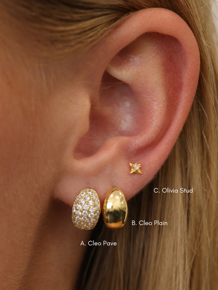 Gold Cleo huggie hoop earrings — chunky dome huggies styled on a neutral background.