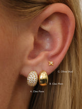 Gold Cleo huggie hoop earrings — chunky dome huggies styled on a neutral background.