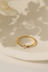 Colette vintage five stone ring in gold on a cream dish with soft shadow