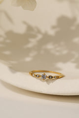 Colette vintage five stone ring in gold on a cream dish, close view
