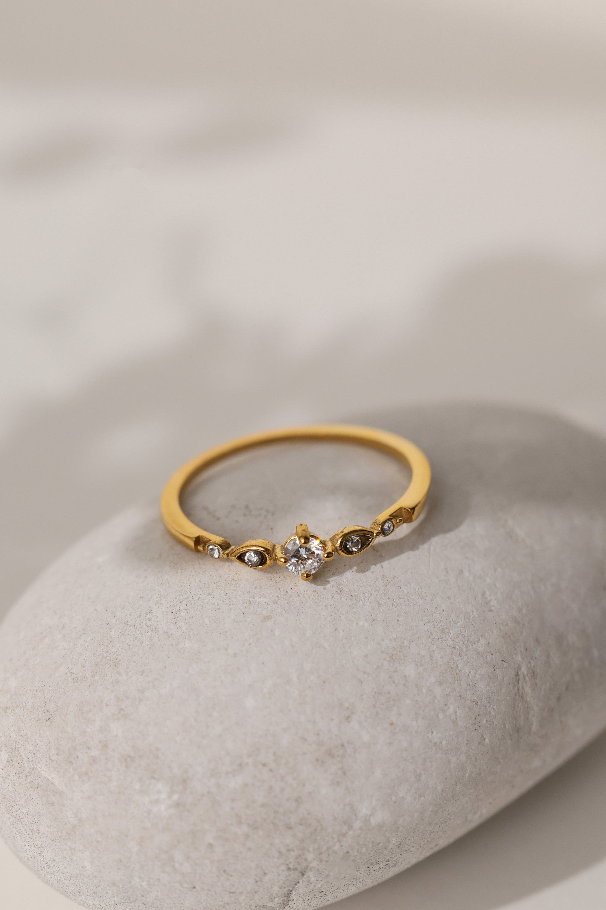 Colette vintage five stone ring in gold resting on a pale stone
