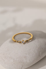 Colette vintage five stone ring in gold resting on a pale stone