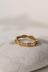 Delphine star eternity band in gold resting on a pale stone